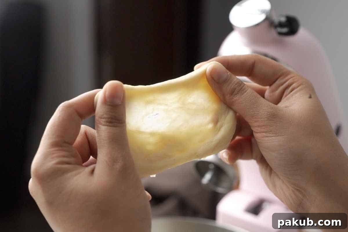 Homemade Bread Made Easy 4 A close-up shot of dough being stretched to demonstrate the windowpane test, showing its translucence