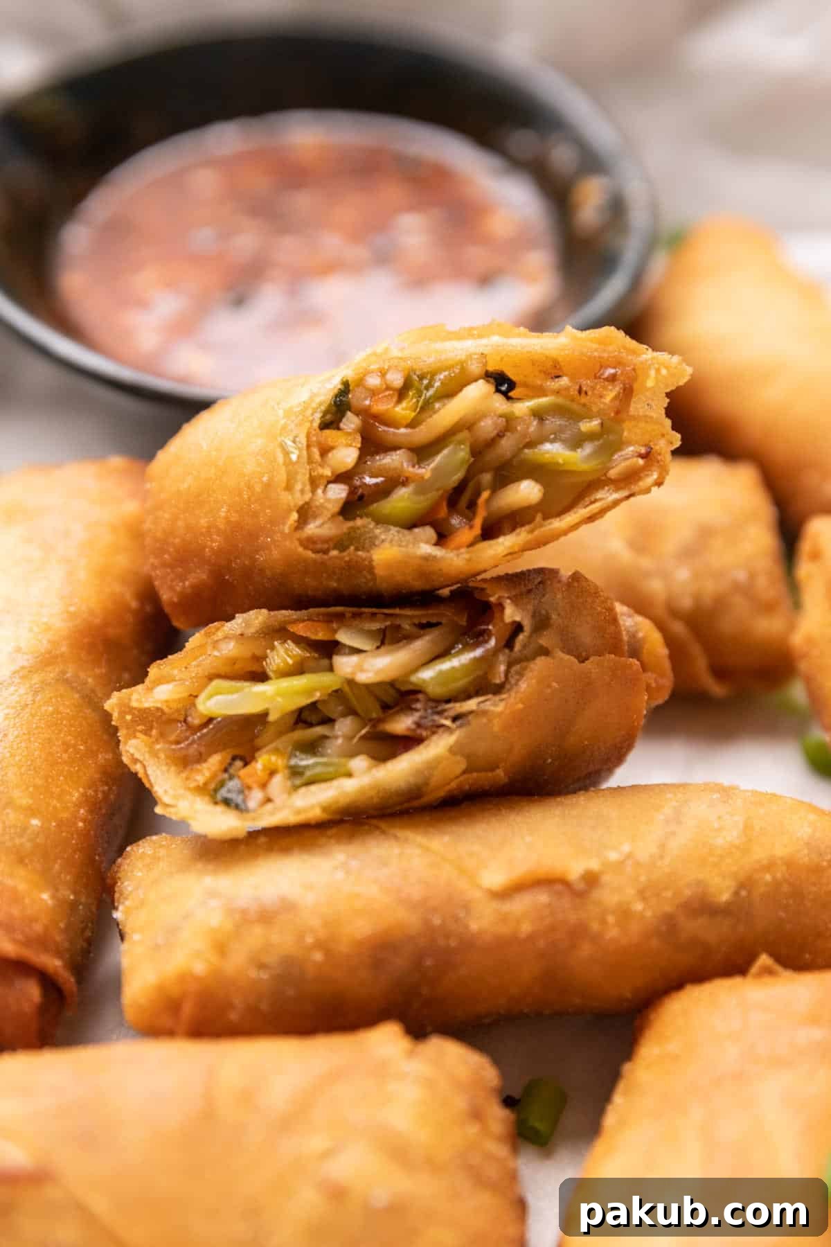 Spring rolls cut in half stacked on top of each other to show the filling and crispy texture