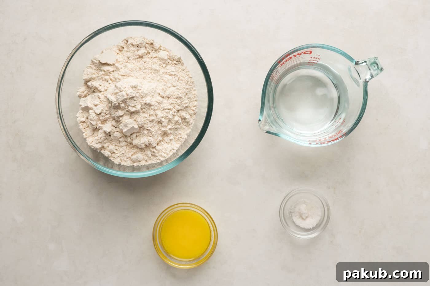 Picture of all the ingredients laid out for making lachha paratha: whole wheat flour, salt, water, and melted ghee.