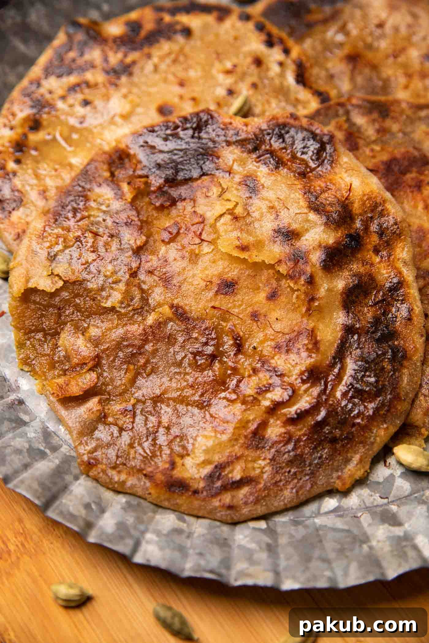 Indian Sweet Lentil Flatbread 9 Puran polis served on a silver platter drizzled with saffron and ghee