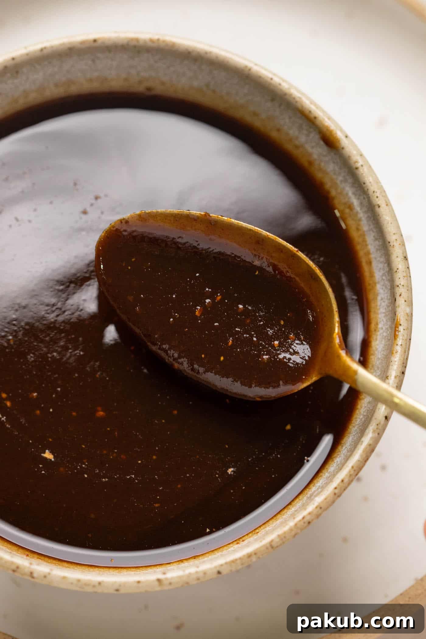 Sweet and Tangy Tamarind Chutney 7 A spoonful of tamarind chutney being taken out of a bowl