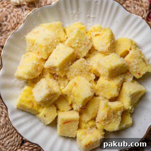 Saffron Milk Pudding Bites presented beautifully in a white bowl, showcasing their creamy texture and vibrant saffron hue, perfect for festive gatherings.