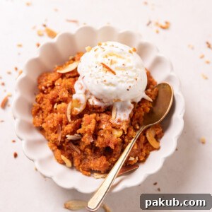 Gajar ka Halwa served in a pristine white bowl, adorned with a scoop of vanilla ice cream and a sprinkle of crunchy almonds, with a spoon resting elegantly on the side.