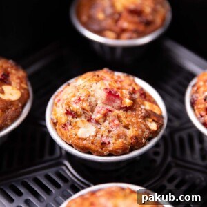 A close-up image of freshly baked strawberry muffins, perfectly golden and fluffy, prepared in an air fryer.