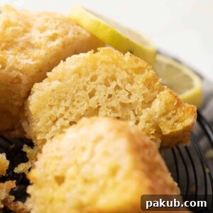 A delicate slice of eggless lemon cake, showcasing its light, airy texture and inviting golden hue.
