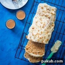 A freshly baked simple eggless wholewheat carrot cake loaf, just out of the oven, showcasing its golden-brown crust and inviting aroma.