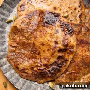Puran Polis served on a silver platter drizzled with saffron and ghee, looking rich and inviting