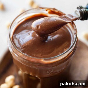 Lush Homemade Nutella chocolate spread in a jar with a spoon.