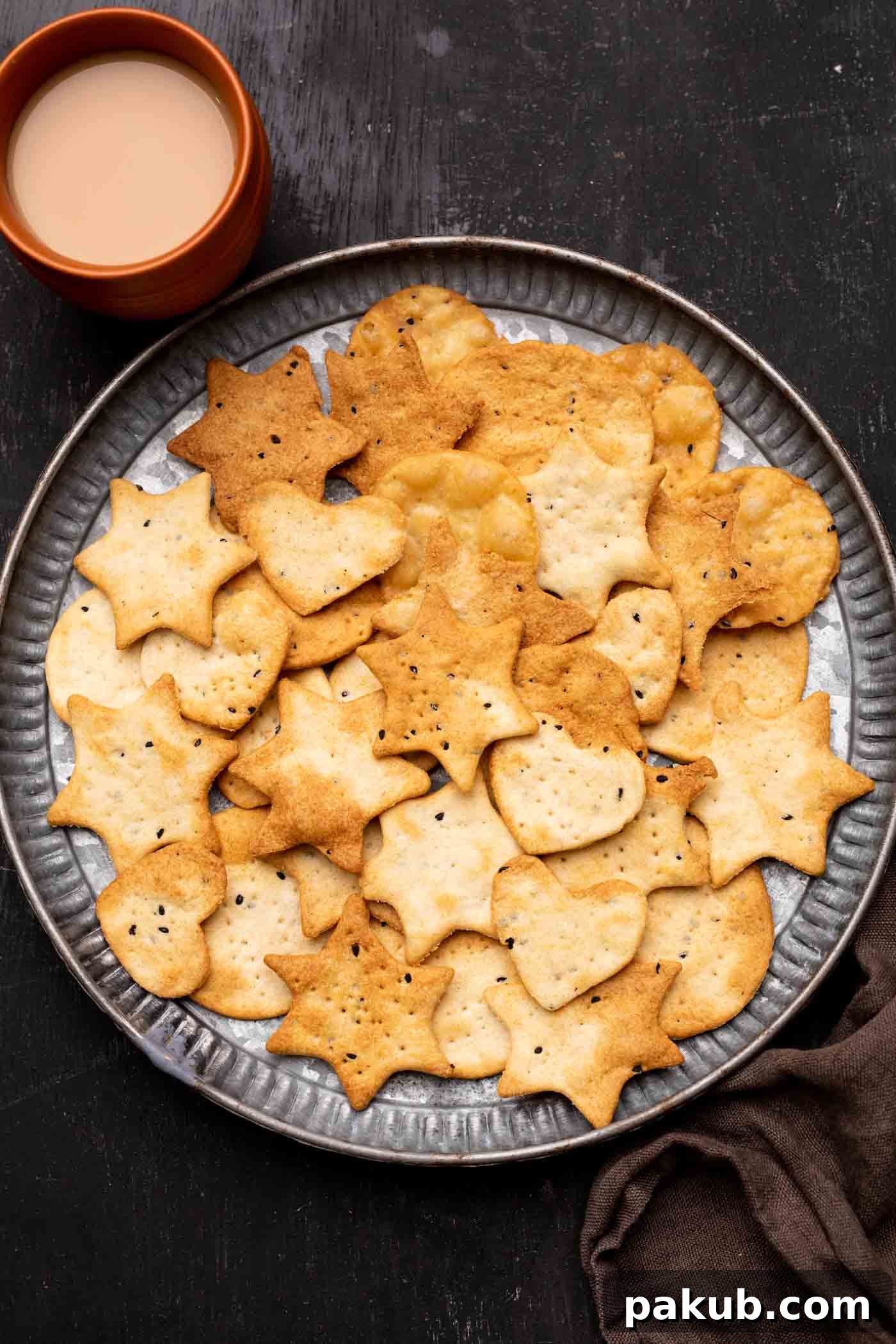 Guilt-Free Air Fryer Papdi 2 Crispy Air Fryer Papdi served elegantly on a plate with a refreshing cup of chai on the side, ready to be enjoyed as a festive snack.