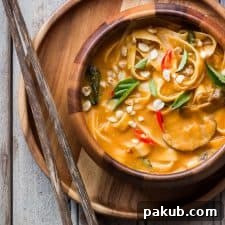 Creamy, comforting spicy Thai curry pumpkin noodle soup, served in a beautiful bowl.
