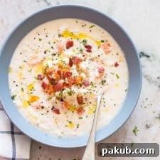 Creamy Cauliflower Chowder, topped with crispy bacon and a drizzle of olive oil, served invitingly in a bowl.