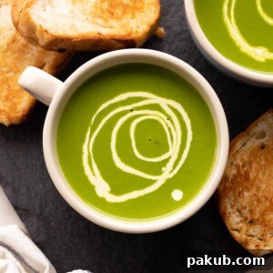 Fresh spinach soup served in a white bowl with toasted bread on the side.