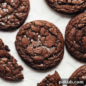 Extra fudgy chocolate brownie cookies sprinkled with sea salt, arranged beautifully on parchment paper.