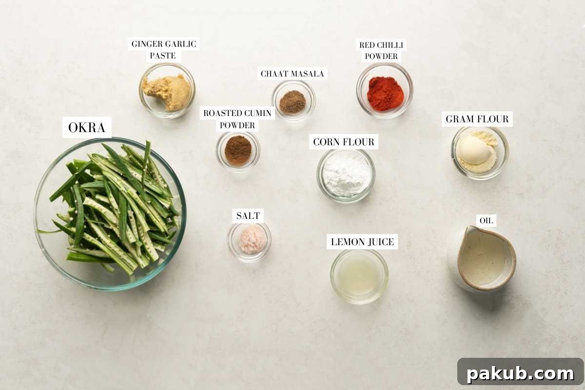 Crispy Air Fryer Okra 4 A clear flat lay image displaying all the ingredients required for Air Fryer Kurkuri Bhindi, neatly arranged with descriptive labels.