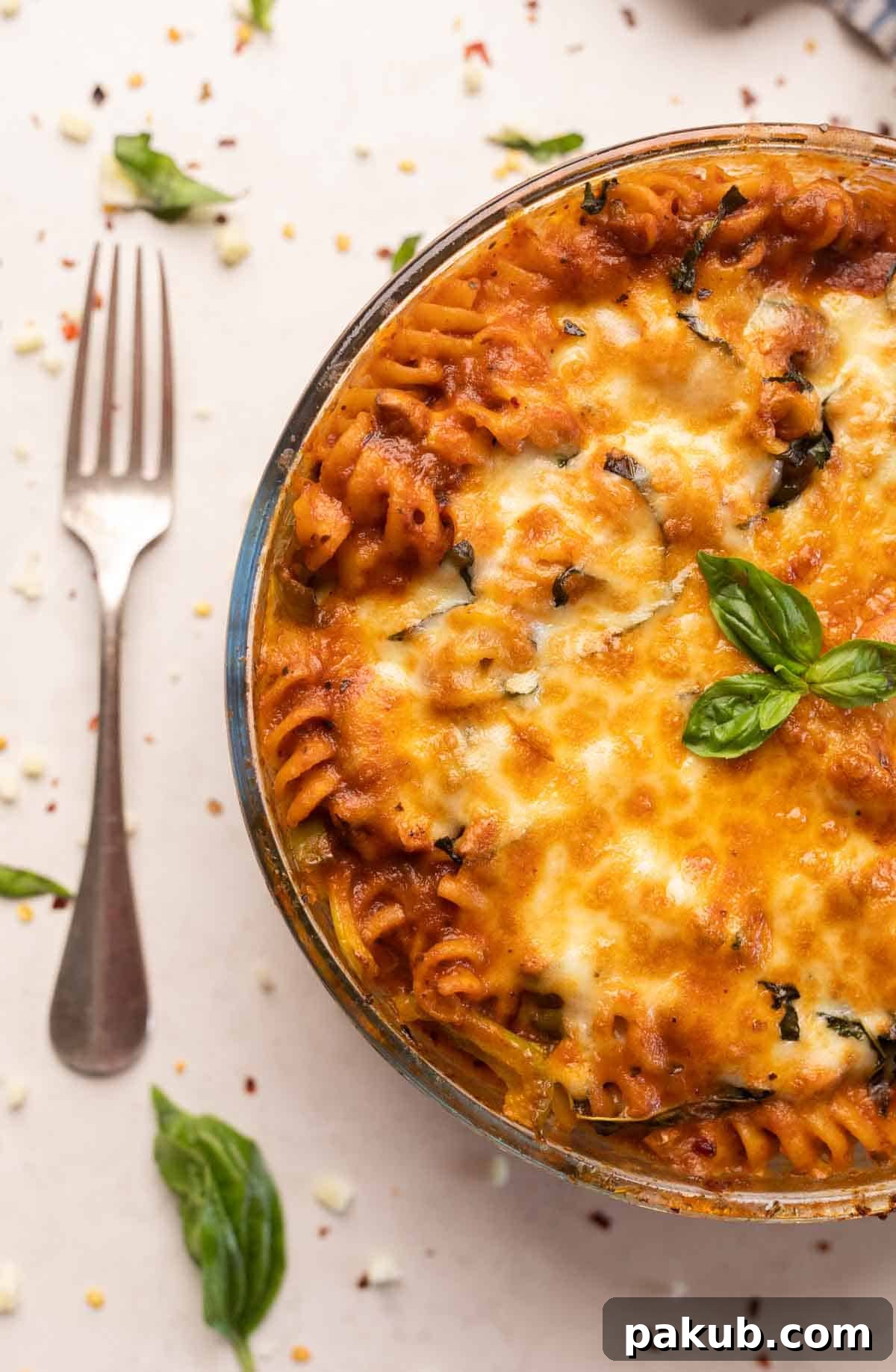 No-Boil Air Fryer Pasta Bake 6 Red sauce pasta made in an air fryer served in a white bowl with melted cheese and basil on top