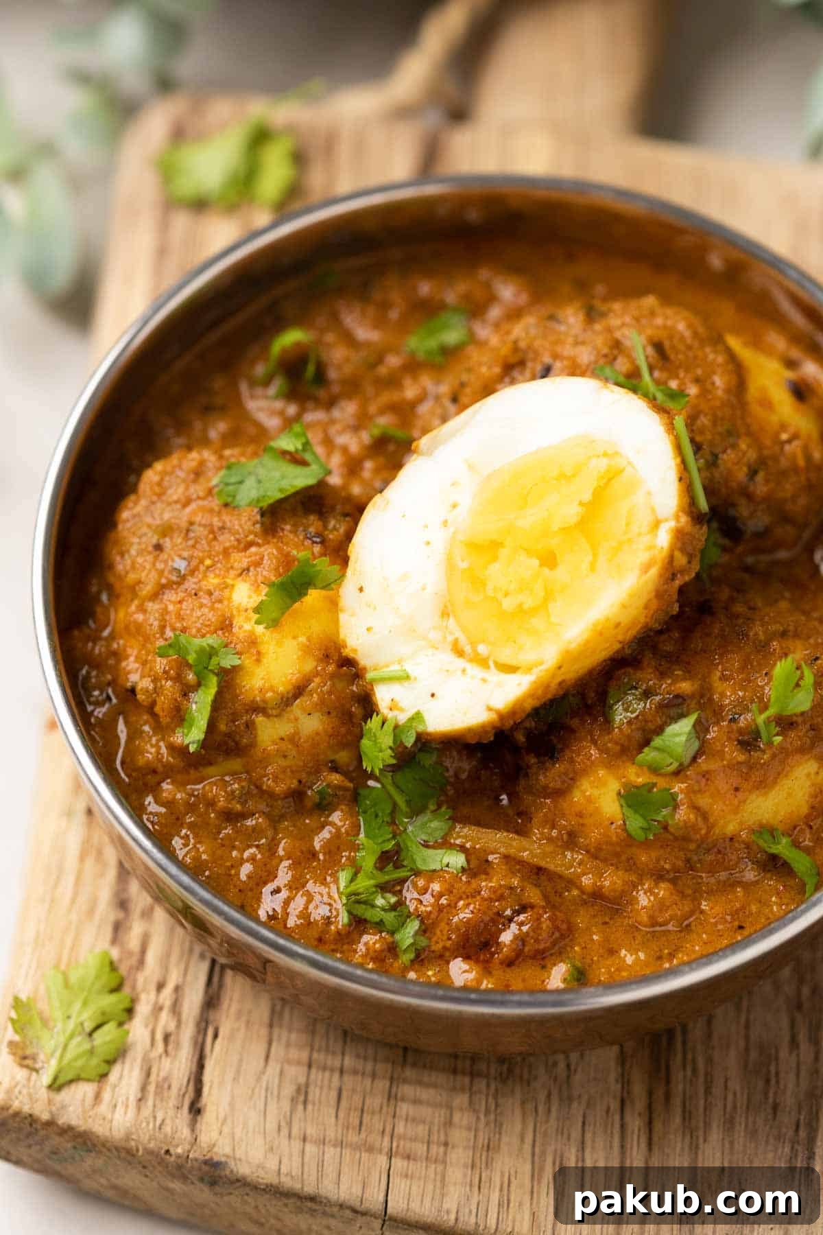 Classic Dhaba Egg Curry 2 A steel bowl filled with rich Dhaba Style Egg Curry, garnished with fresh coriander leaves, ready to be served.