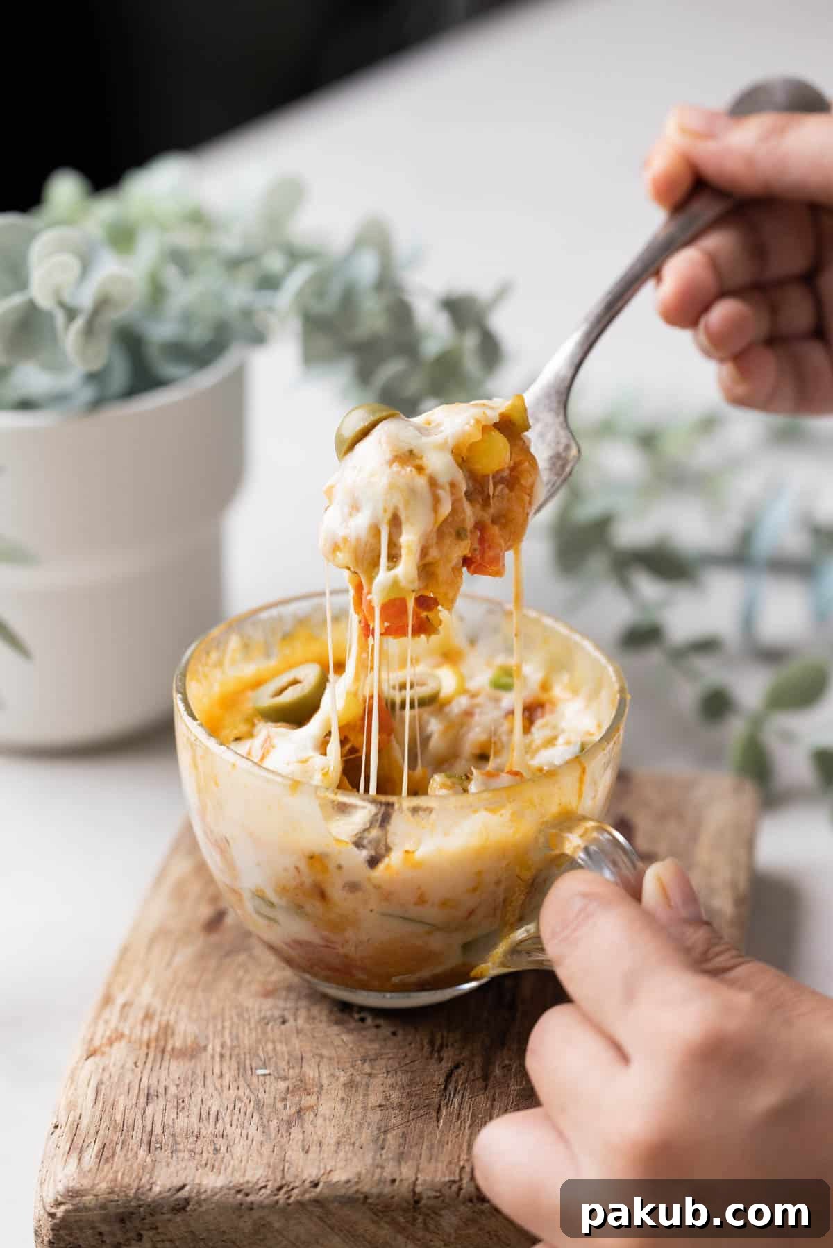 Savoury Mugs in Minutes 4 Irresistible shot of microwave pizza in a mug with a fork pulling out a cheesy, bubbly bite