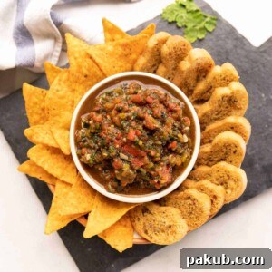 Roasted tomato salsa served with nachos and crostini on the side, ready to be enjoyed as a vibrant dip.