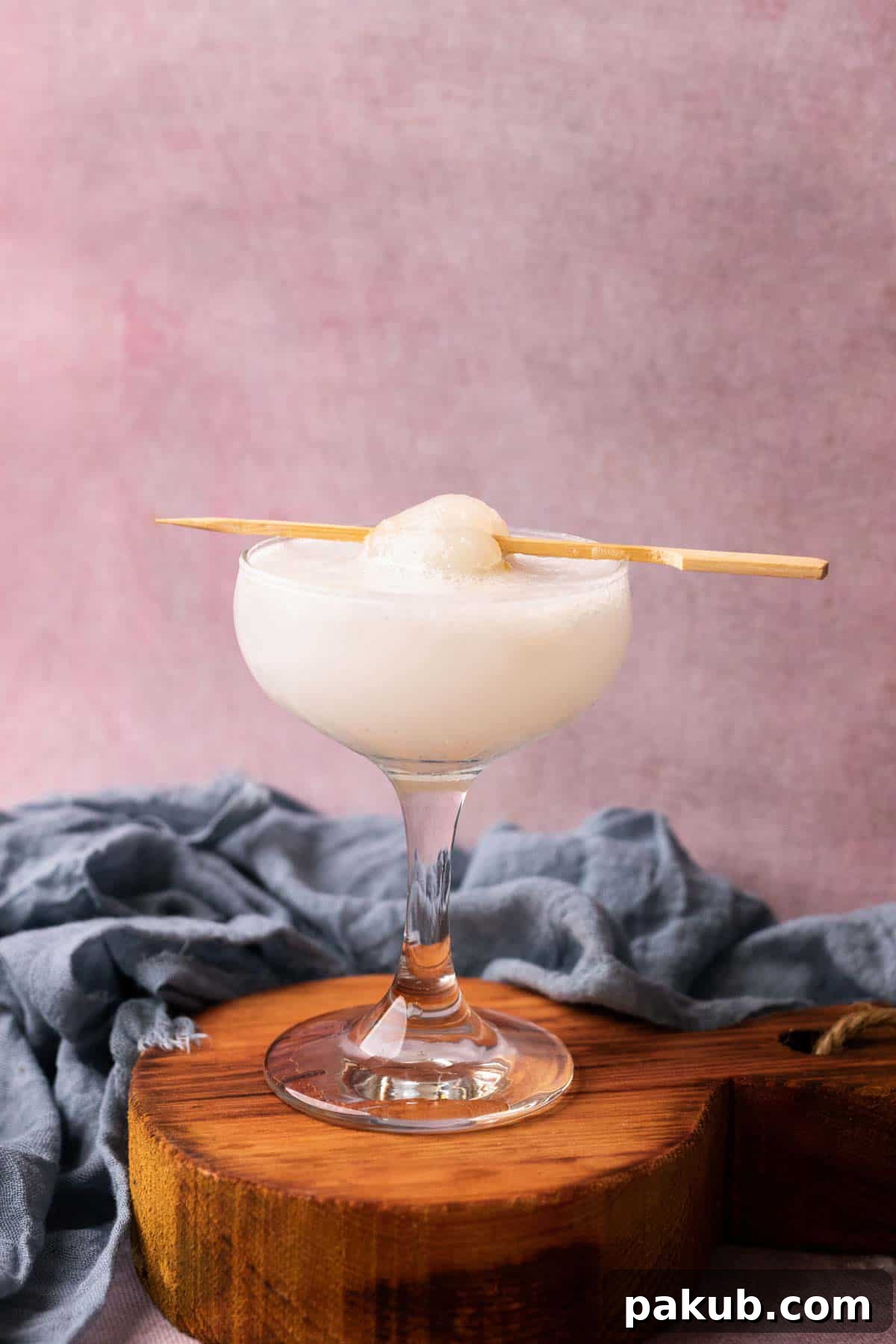 Close-up of a refreshing Lychee Soda, garnished with a lychee on a toothpick, highlighting its creamy, slushy texture.