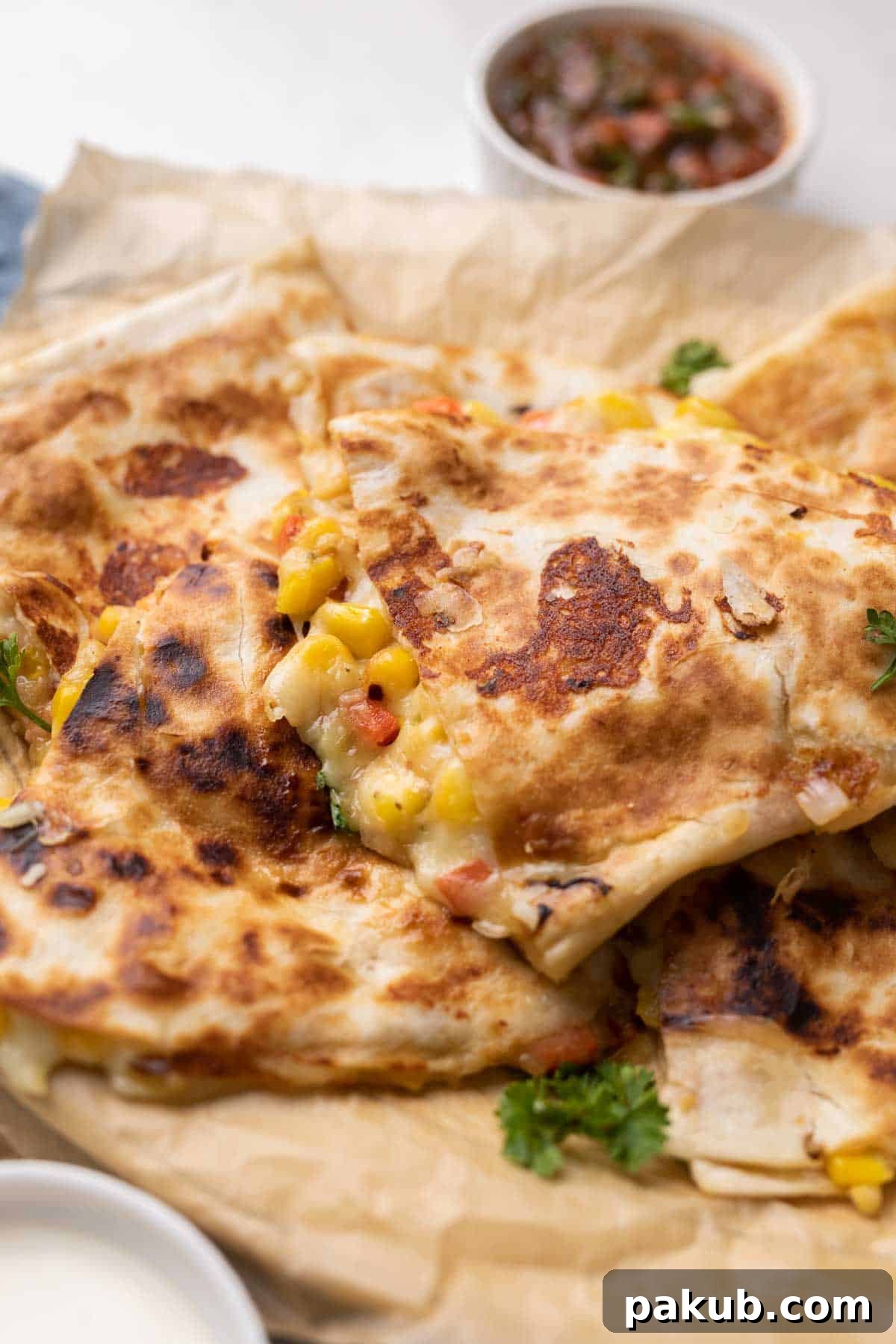 Crispy golden-brown bell pepper, corn, and cheese quesadilla with visible melted cheese and vibrant vegetable bits, served alongside a bowl of fresh tomato salsa for dipping.