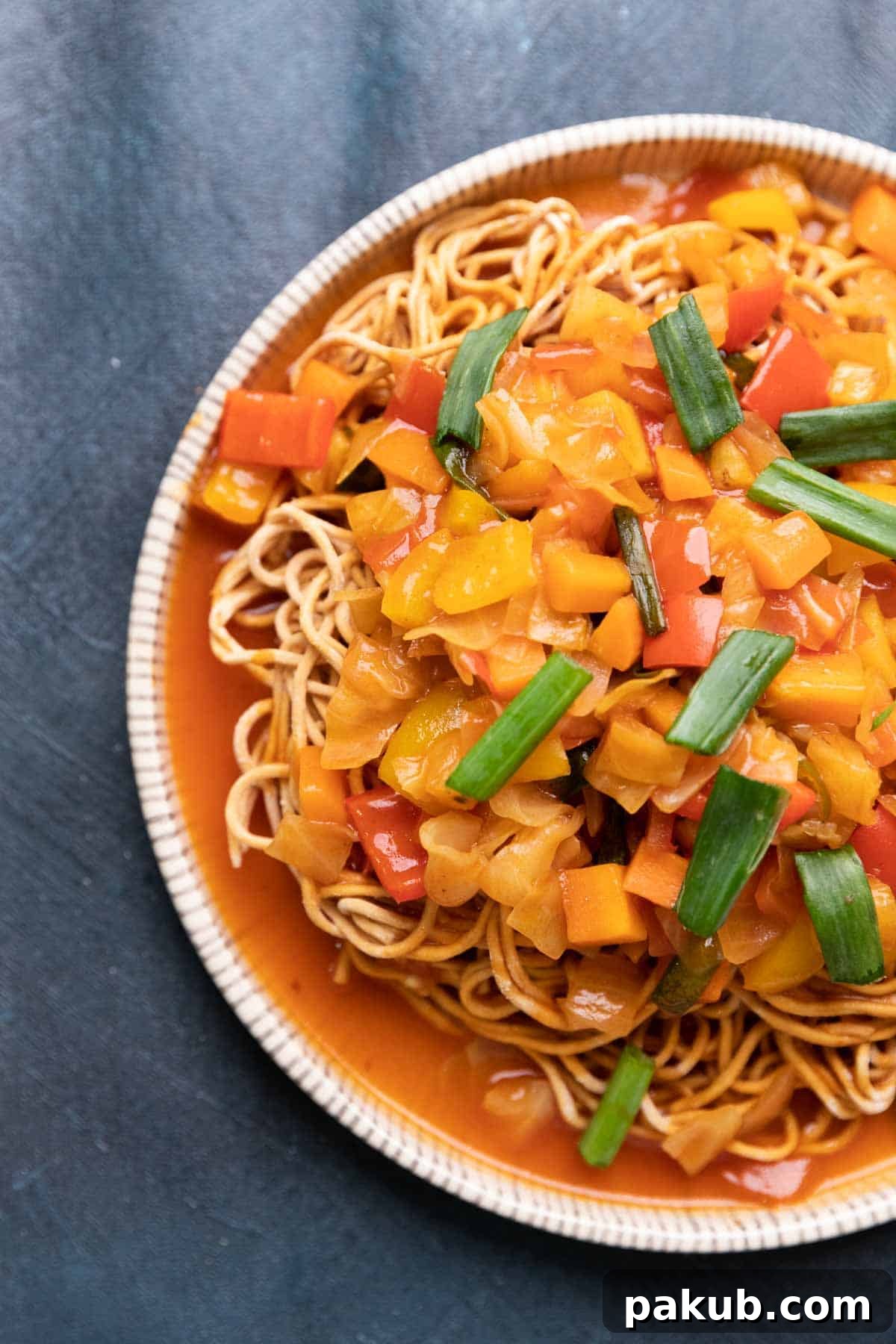 Crispy Noodle Nest with Tangy Sweet and Sour Vegetables 2 A plate of golden crispy noodles topped generously with colorful sweet and sour vegetables and garnished with fresh spring onions.