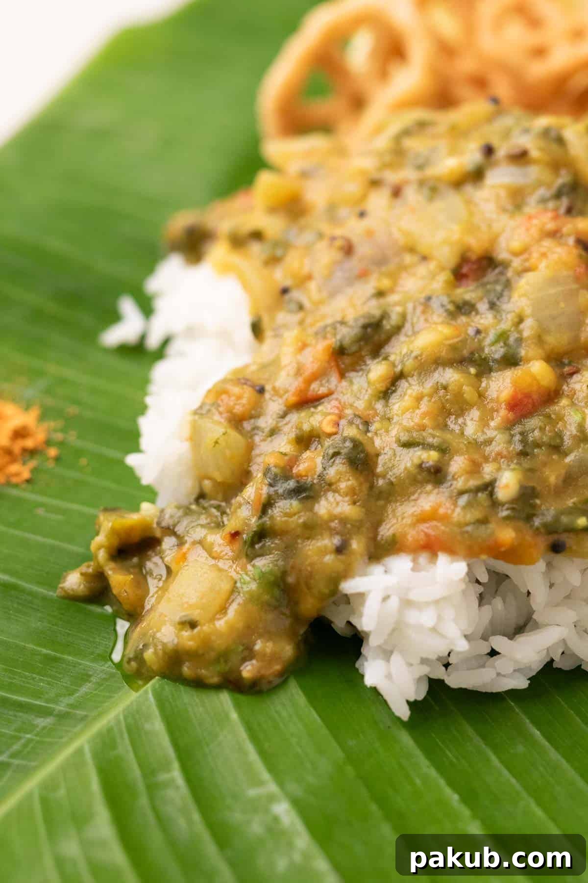 Andhra Style Palak Pappu served with steamed rice on a traditional banana leaf, accompanied by crispy fryums and spicy chutney powder (podi)