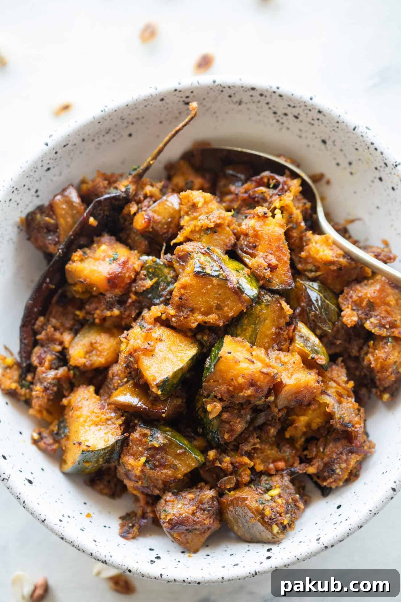 Peanut Pumpkin Sabzi served in a white bowl, garnished with fresh coriander