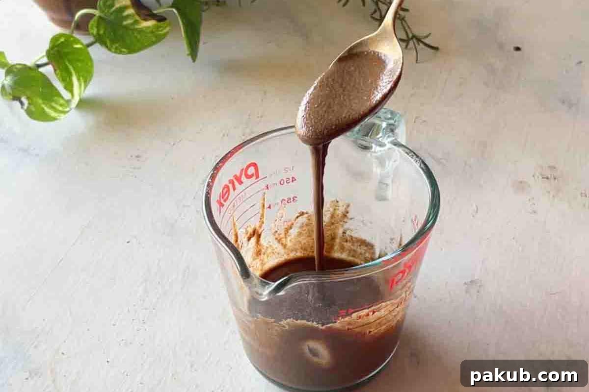 Step-by-step image illustrating the process of mixing all the ingredients together in a bowl to create a smooth pancake batter.