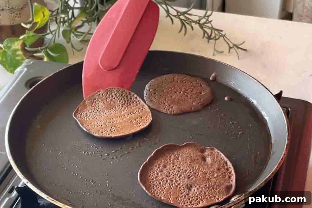 Step-by-step image showing a pancake being expertly flipped on the pan, revealing a golden-brown underside.