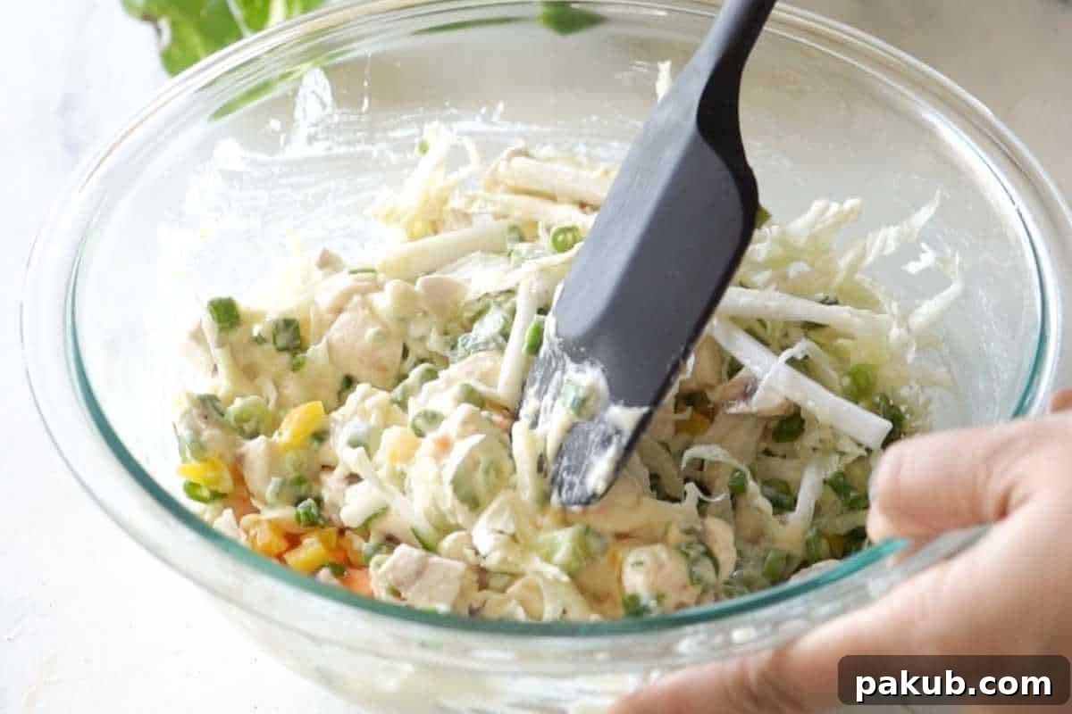 A large mixing bowl containing freshly prepared vegetable pancake batter, showcasing a vibrant and even distribution of finely chopped vegetables within the thick, ready-to-cook mixture.