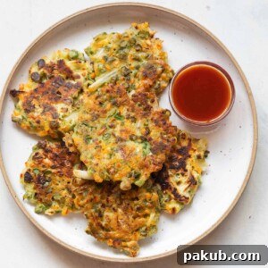 Vegetable pancakes served on a white plate with ketchup on the side