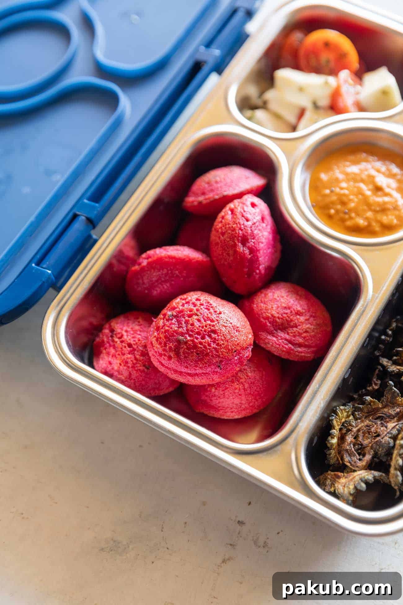 Vibrant Beetroot Appe Paddu Paniyaram 4 Delicious beetroot paniyaram neatly packed in a tiffin box, ready for a healthy and colorful lunch or snack on-the-go.