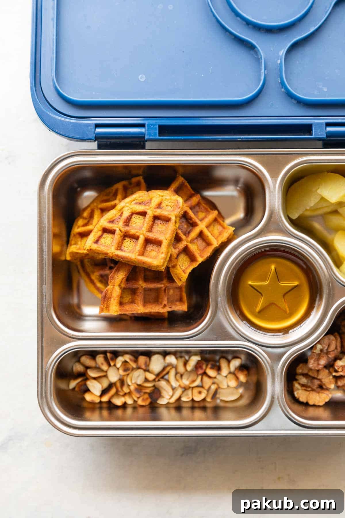 Golden Pumpkin Spice Waffles 6 Pumpkin waffles presented in a kid's lunch box alongside other healthy foods, emphasizing their versatility.