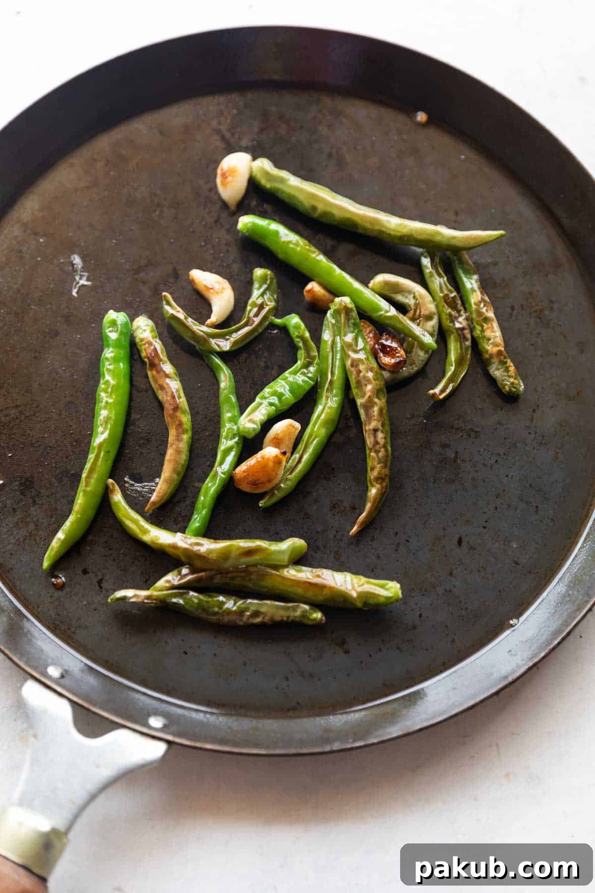 Spicy Naan Fusion: Chilli Garlic and Thecha 4 Roasted garlic cloves and vibrant green chillies, essential ingredients for authentic Thecha.