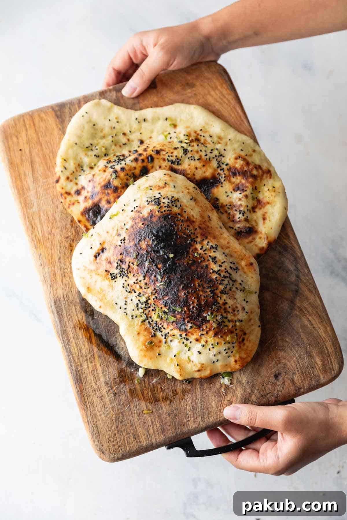 Spicy Naan Fusion: Chilli Garlic and Thecha 5 Golden brown Thecha Naan resting on a rustic wooden board, ready to be served.