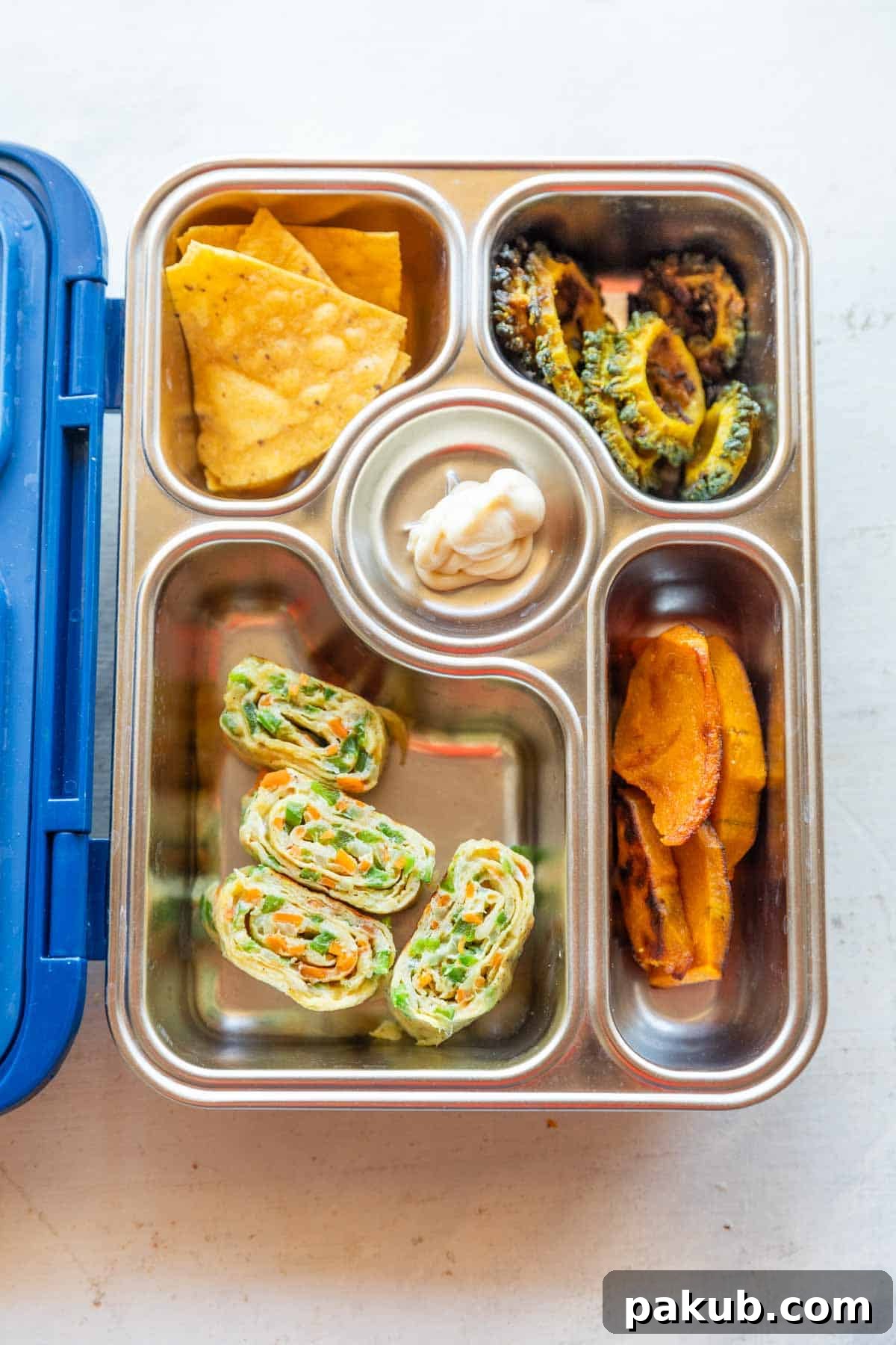 Fluffy Korean Egg Rolls 8 A picture of a tiffin box showcasing various food items, including perfectly portioned Korean omelette rolls, highlighting their suitability for packed lunches.