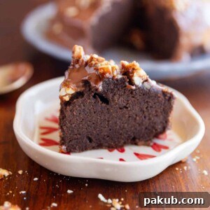 A delectable slice of ragi chocolate cake on a white plate, beautifully garnished with scattered nuts.