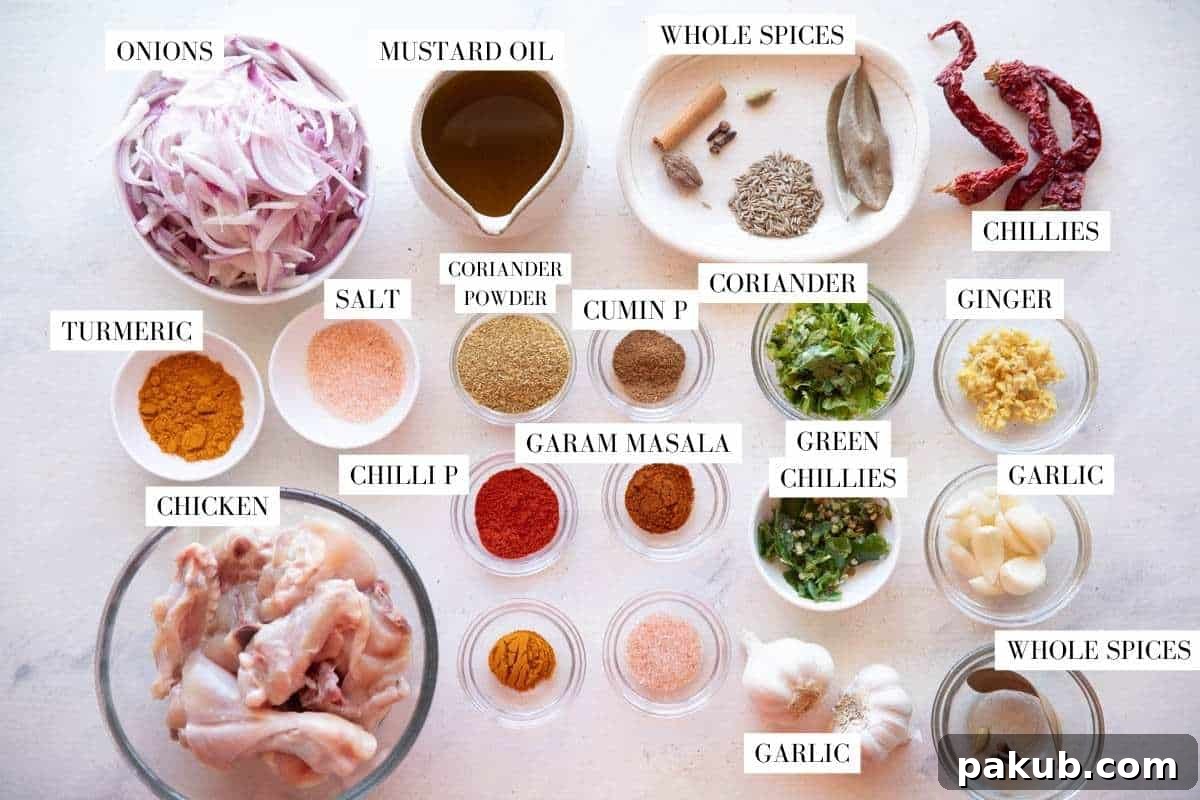 A flat lay photograph showcasing all the fresh and dried spices, vegetables, and chicken pieces required to make authentic Bihari Chicken Curry, neatly arranged on a rustic wooden background.
