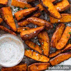 Chilli Lime Sweet Potato Wedges, freshly baked and served on a tray with a complementary dipping sauce.