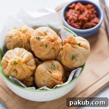 Chinese Potli Samosa Wontons, a delightful fusion snack, served with a vibrant and spicy Schezwan sauce for dipping.