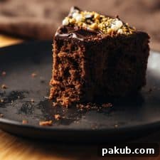 A delicious bite of eggless chocolate cake, showcasing its incredibly soft and moist texture.
