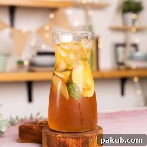 A pitcher of Virgin Apple Iced Tea, non-alcoholic and refreshing, with vibrant apple slices floating inside.