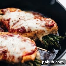 Asparagus Stuffed Chicken Parmesan, beautifully topped with marinara sauce and cooked in a classic cast iron pan.