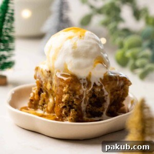 Decadent Sticky Toffee Pudding served on a white dessert plate, generously topped with vanilla ice cream and warm toffee sauce.