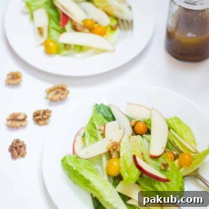 Crisp Apple Walnut Summer Salad served in elegant white bowls, featuring fresh greens, crunchy apples, and toasted walnuts, all lightly coated in a zesty vinaigrette.