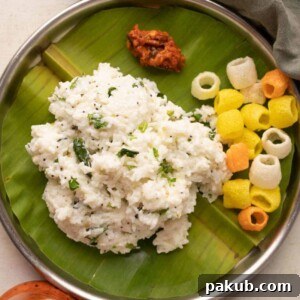 Comforting Curd Rice, a summer special, elegantly served on a plate with traditional accompaniments of pickle and crispy fryums, offering a delightful South Indian experience.