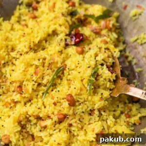 Fragrant Raw Mango Rice, also known as Maavinakayi Chitranna, prepared in a traditional kadai with a ladle, showcasing its colorful and tangy appeal.