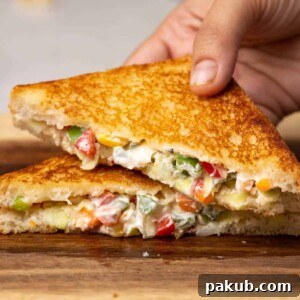 A hand reaching for a delicious slice of Hung Curd Sandwich, showcasing its creamy filling and appealing presentation, ideal for a quick and healthy snack.