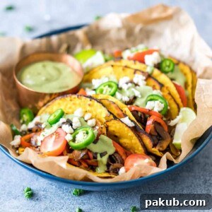 Delectable Vegetarian Portobello Mushroom Fajita Tacos, beautifully presented with a side of creamy avocado cilantro sauce, offering a fresh and savory plant-based option.