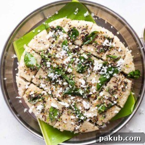Fluffy and healthy Jowar Dhokla (Sorghum Dhokla) served on a banana leaf, accompanied by a side of fresh coconut chutney, creating a delightful and traditional Indian snack.